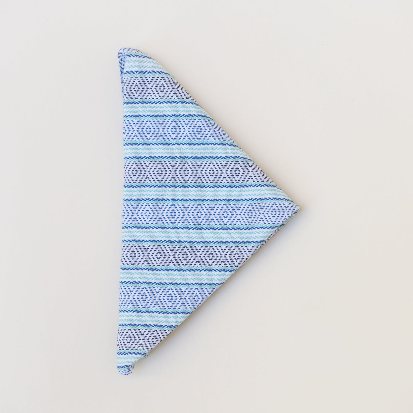 Blue patterned fabric folded into a triangle on a light gray background